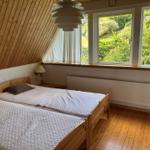 Bedroom with wooden floor, double bed, and view of green landscape.