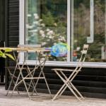 Outdoor area with table and chairs, beside a net and a stick.