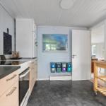 Kitchen with refrigerator, worktop, and waste sorting system.