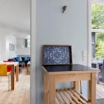 House with dining area, terrace, and blue-white tile artwork on the wall.