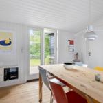 Dining room with wooden table, chairs, and window to the garden.