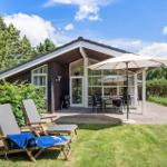 Haus mit Terrasse, Sonnenschirm, Grill und Liegestühle im Garten.