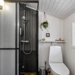 Dusche mit Duschbrause, Toilette und Fenster mit Milchglas
