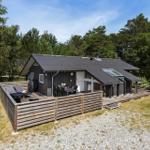 Ein modernes Holzhaus mit Terrasse, Grill und Sitzgelegenheiten im Wald.