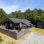 Moderne Holzhütte mit Terrasse, Grill und Garten. Umgeben von Wald und klarer Luft.