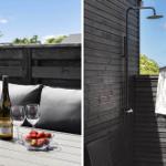 Terrasse mit Tisch, Stühlen, Wein und Erdbeeren. Dusche im Freien an Holzwand.