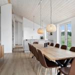 Esszimmer mit Holztisch, braunen Stühlen und Fenster zur Landschaft.