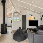 Wohnraum mit Kamin, Sofa und Sitzgelegenheit. Holzwände und Decke.