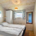 Schlafzimmer mit Holzwand, Bett, Fenster und Spiegel.