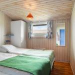 Schlafzimmer mit Bett, Kleiderständer und Fenster. Holzwand und Decke.
