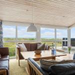 Wohnzimmer mit Blick auf Strand und Meer durch große Fenster.