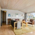Wohnzimmer mit Holzboden, Sofa, Tisch und großen Fenstern.