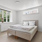 Schlafzimmer mit Bett, Fenster und Bücherregal.