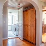 Hausgang mit Holzschrank, Spiegel und Blick in Waschraum und Schlafzimmer