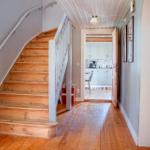 Haus mit Holztreppe und Küchenansicht durch offene Tür