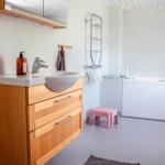 Bad mit Waschbecken, Duschbereich und Badewanne.