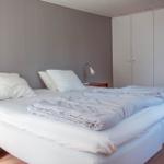 Schlafzimmer mit Doppelbett, weißen Kissen und Kleiderschrank.