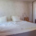 Schlafzimmer mit Bett, Stehlampe und weißer Zentralheizung.