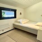 Ein Schlafzimmer mit Bett, Fenster und Teppichboden.