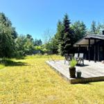 Haus mit Terrasse, Garten und Sitzgelegenheiten unter freiem Himmel.