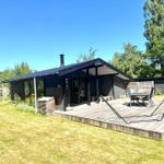 Moderne Hütte mit Terrasse, Sitzgelegenheiten und Garten. Holzterrasse mit Liege.