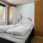 Schlafzimmer mit Bett, Fenster und Holzmöbeln.