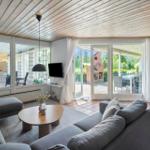 Wohnbereich mit Sofa, Couchtisch und TV. Durchgänge zu Terrasse und Bad.