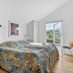 Schlafzimmer mit Bett, Schrank und Tür zum Außenbereich.