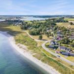 Aerielansicht einer Küstenlandschaft mit Häusern, Strand und Wasser.