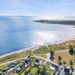 Aerielansicht eines Strandes mit Häusern und Meer