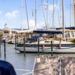 Hafen mit mehreren Segelyachten und Booten im Wasser.