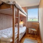 Zimmer mit Doppelstockbett, Holzwand und Fenster mit Blick.