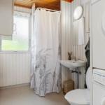 Badezimmer mit Dusche, Waschbecken und Waschmaschine