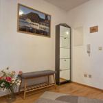 Eingangsbereich mit Bank, Blumen und Schrank. Durchgang in die Küche.