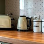 Küchenzeile mit Toaster, Kaffeekanne und Aufbewahrungsdosen für Kaffee und Tee.
