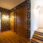 Hausflur mit Holzboden, floraler Tapete und Treppe zur oberen Etage.