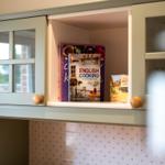 Küchenregal mit Kochbüchern und Holzgriffen