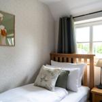 Ein Schlafzimmer mit Bett, Fenster und Wandbild von Enten.