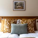 Ein Bett mit Kissen und einer Wanddekoration über dem Kopfteil.
