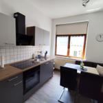 Kitchen with dining area, window, and wall clock