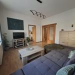Living room with sofa, coffee table, TV, and wooden floor.