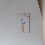 Ein Bild mit einer Möwe in einem gestreiften Hemd und einer Mütze hängt an der Wand.