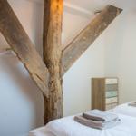 Schlafzimmer mit rustikalem Holzrahmen und Bett mit weißer Bettwäsche.