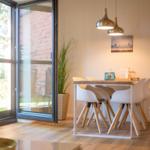 Essbereich mit Tisch, Stühlen und Glasfront zum Außenbereich.