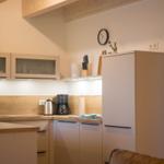 Küche mit Holzbalken, Kühlschrank und Kaffeemaschine