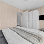 Schlafzimmer mit Bett, Kleiderschrank und Fernseher an der Wand.