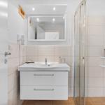 Badezimmer mit Dusche, Waschbecken und Spiegel