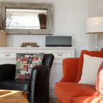 A living room with a red sofa, a black chair, and a white cabinet.
