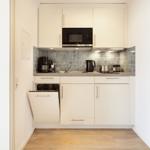 Kitchen with white cabinets, microwave, sink, and integrated dishwasher.