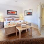 Bedroom with bed, nightstands, and decorative pictures on the walls.